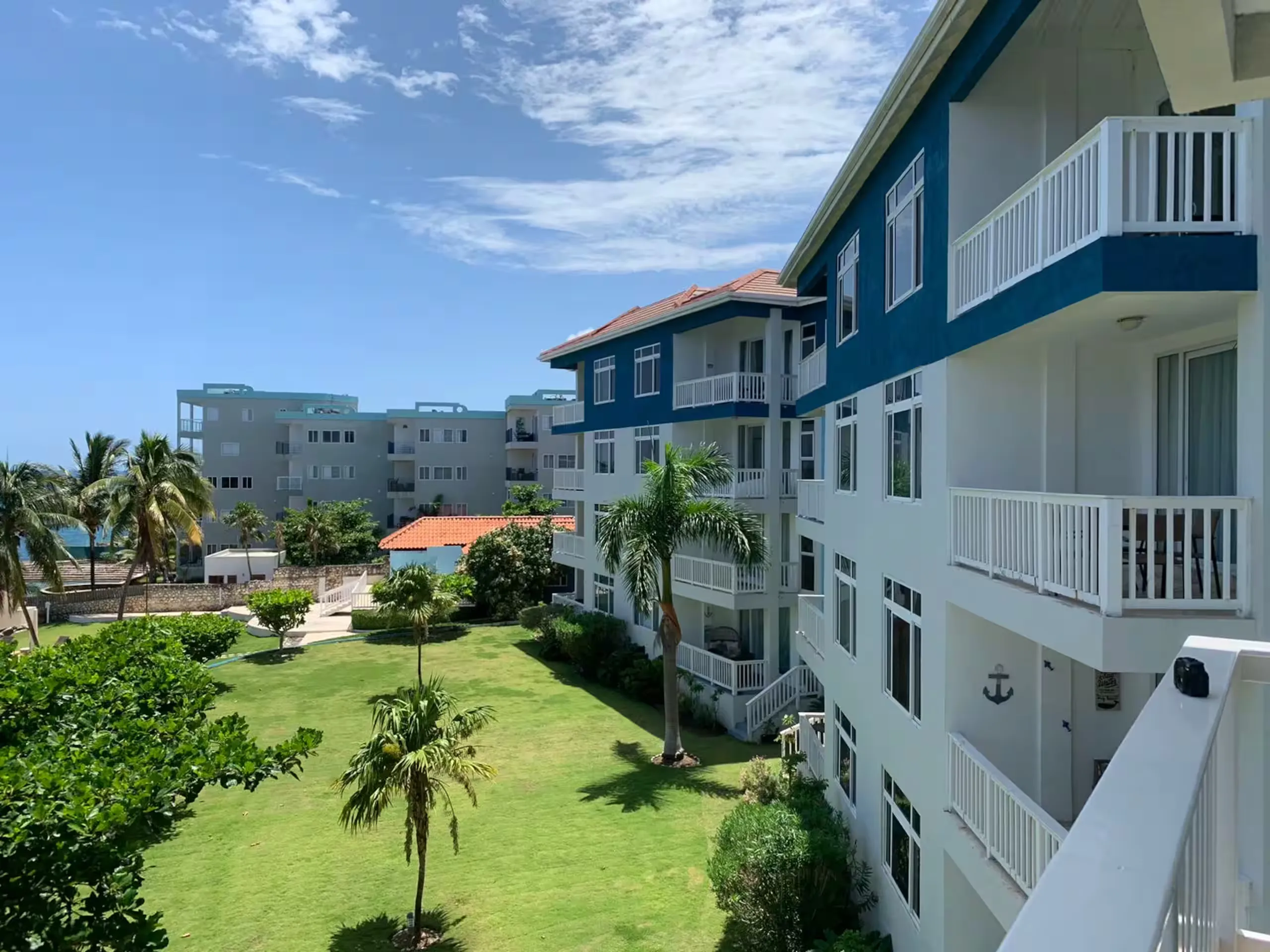 The three-storey blue-and-white Whispering Seas building with its garden.